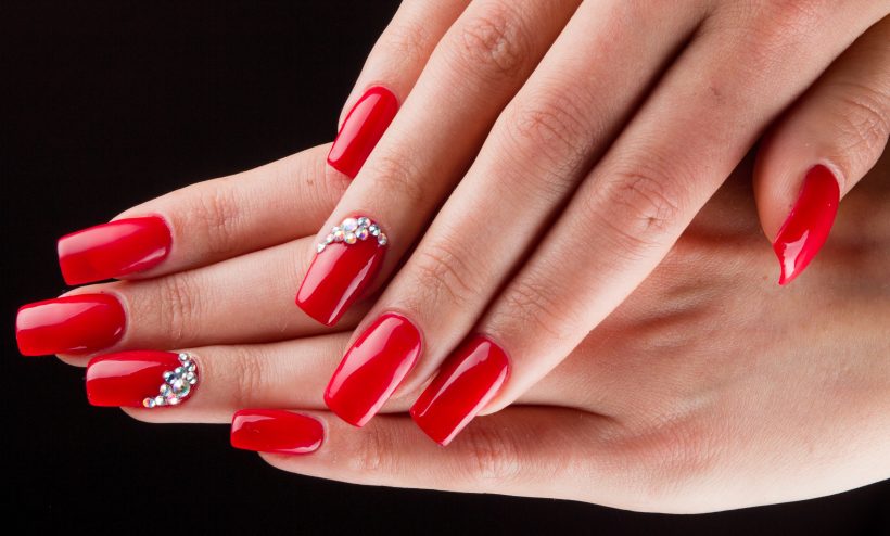 デコパーツのついたレッドカラーネイル