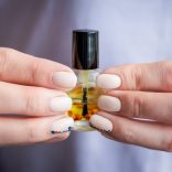 キューティクルオイルを持つ手元